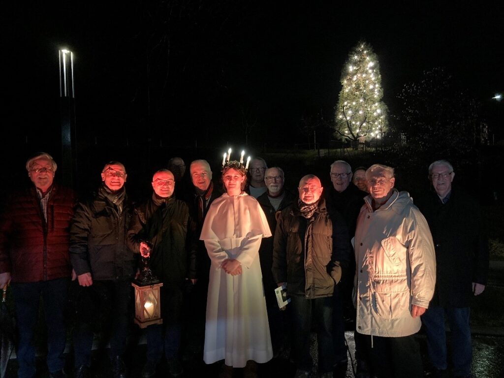 Männerchor mit Lucia vor Weihnachtsbaum